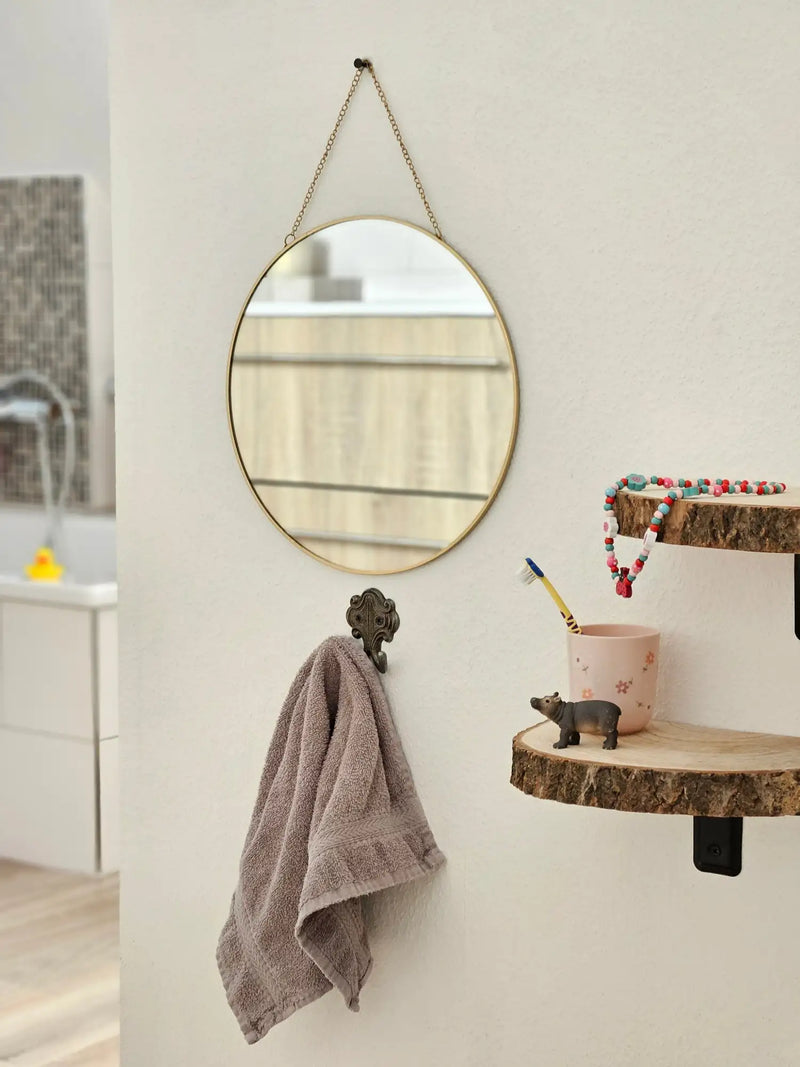 Runder Spiegel mit einem dünnen Goldrahmen, der an einer Kette hängt